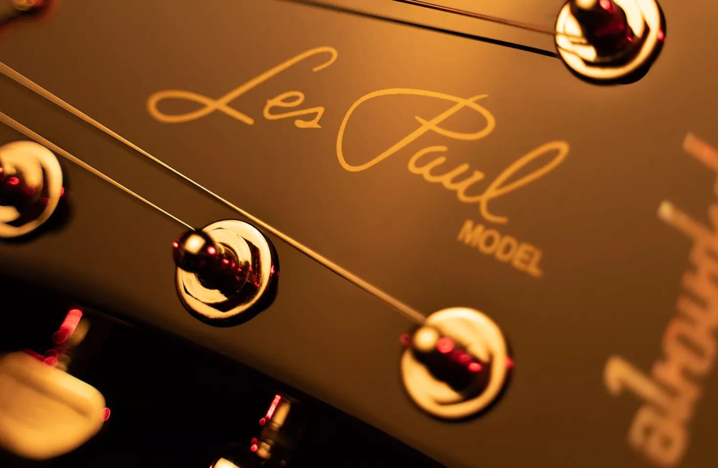 Gold Les Paul Model signature on a Gibson headstock under warm light